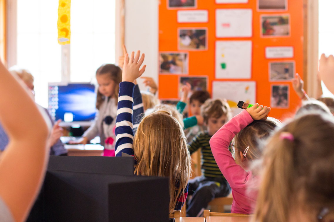 photo of young ISSH students talking and raising hands